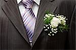 White rose boutonniere on groom's wedding suit