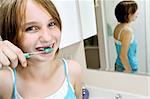 Young girl brushing her teeth in a bathroom