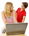 Teen girl using computer and talking with her little brother.  Isolated on white.