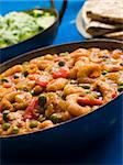 Bowl of Prawn Patia with Side dishes of Green Rice and Chapatti