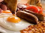 Dipping Toast into a Fried Egg on a Full English Breakfast