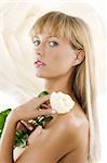 beautiful young woman with long blond hair an a white rose on her shoulder