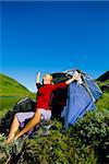 Young woman waking up next to tent