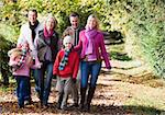 Multi-generation family walking through autumn woods