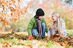 Two children collecting autumn leaves