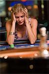 Woman losing at roulette table in casino