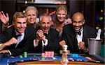 Group of friends celebrating win at roulette table in casino