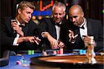 Group of men gambling at roulette table in casino