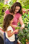 Mother and daughter in supermarket produce section