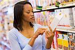Female shopper checking food labelling in supermarket