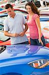 Couple looking at new cars on lot