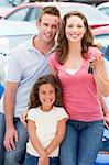 Young family collecting new car from lot