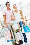 Family shopping in mall carrying bags