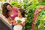Mother and daughter choosing fresh produce in supermarket
