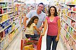 Young family grocery shopping in supermarket