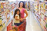 Mother and daughter grocery shopping in supermarket