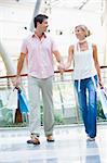 Young couple shopping in mall carrying bags