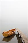 Boat at a landing stage of a lake on a misty morning