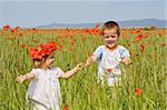 Kids on poppy field in summer time - slight motion blur on the boy