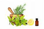 Fresh herb selection of rosemary, bay leaves and half a lemon and an essential oil brown glass aromatherapy bottle, with an olive wood pestle and mortar. Over white background.