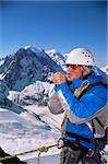 Young man warming hands on mountain peak