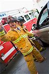 Firefighters cutting open a car to help an injured person