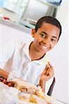 Schoolboy enjoying his lunch in a school cafeteria
