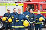 Portrait of a group of firefighters by a fire engine