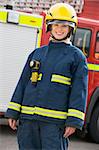 Portrait of a firefighter standing in front of a fire engine