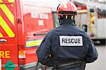 A firefighter standing by a small fire engine