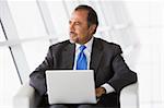 Businessman using laptop in office lobby