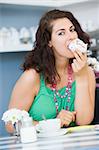 A young woman eating cake in a cafe