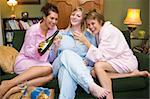 Three young women drinking wine together in their pyjamas