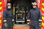 Firefighters standing by the equipment in a small fire engine