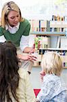 Kindergarten teacher showing seedling to children