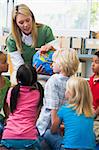 Kindergarten teacher and children looking at globe