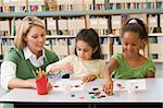 Kindergarten teacher sitting with students in art class