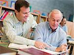 Tutor assisting mature student in library