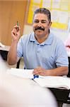 Mature male student raising hand in class