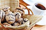 Fresh sandwich cookies in a basket and espresso coffee