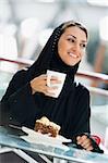 A Middle Eastern woman enjoying a meal in a restaurant