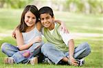 Two children sitting in park together