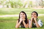 Two children relaxing in park together