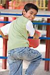 Boy on climbing frame in playground