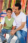 Father and son in playground on climbing frame