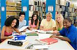Group of six students working around table in library
