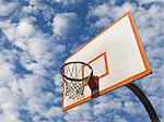 A basketball ring over a blue sky with clouds.