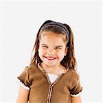 Cute little hispanic girl standing smiling.