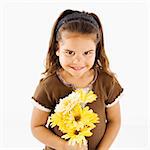 Lttle hispanic girl holding bouquet of yellow flowers.