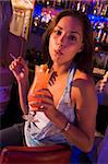 Young woman drinking and smoking at a bar